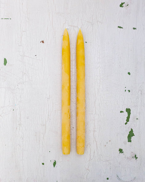 two bright yellow beeswax taper candles by Huckleberry Hives.