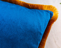 square blue velvet throw pillow with gold fringe