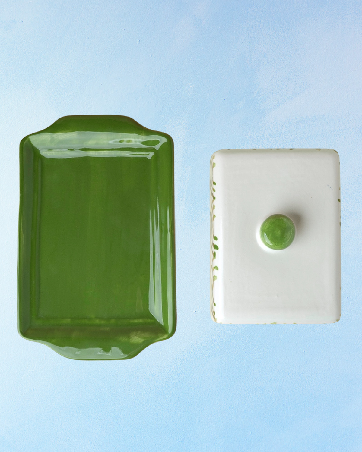 ceramic butter dish with a green bottom base and white lid with green accents