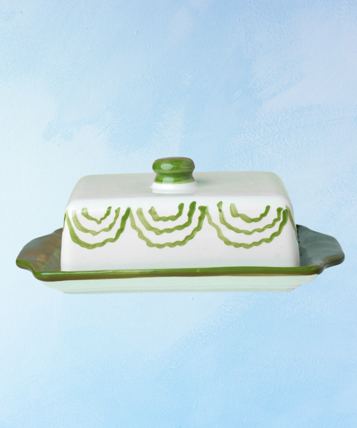 ceramic butter dish with a green bottom base and white lid with green accents