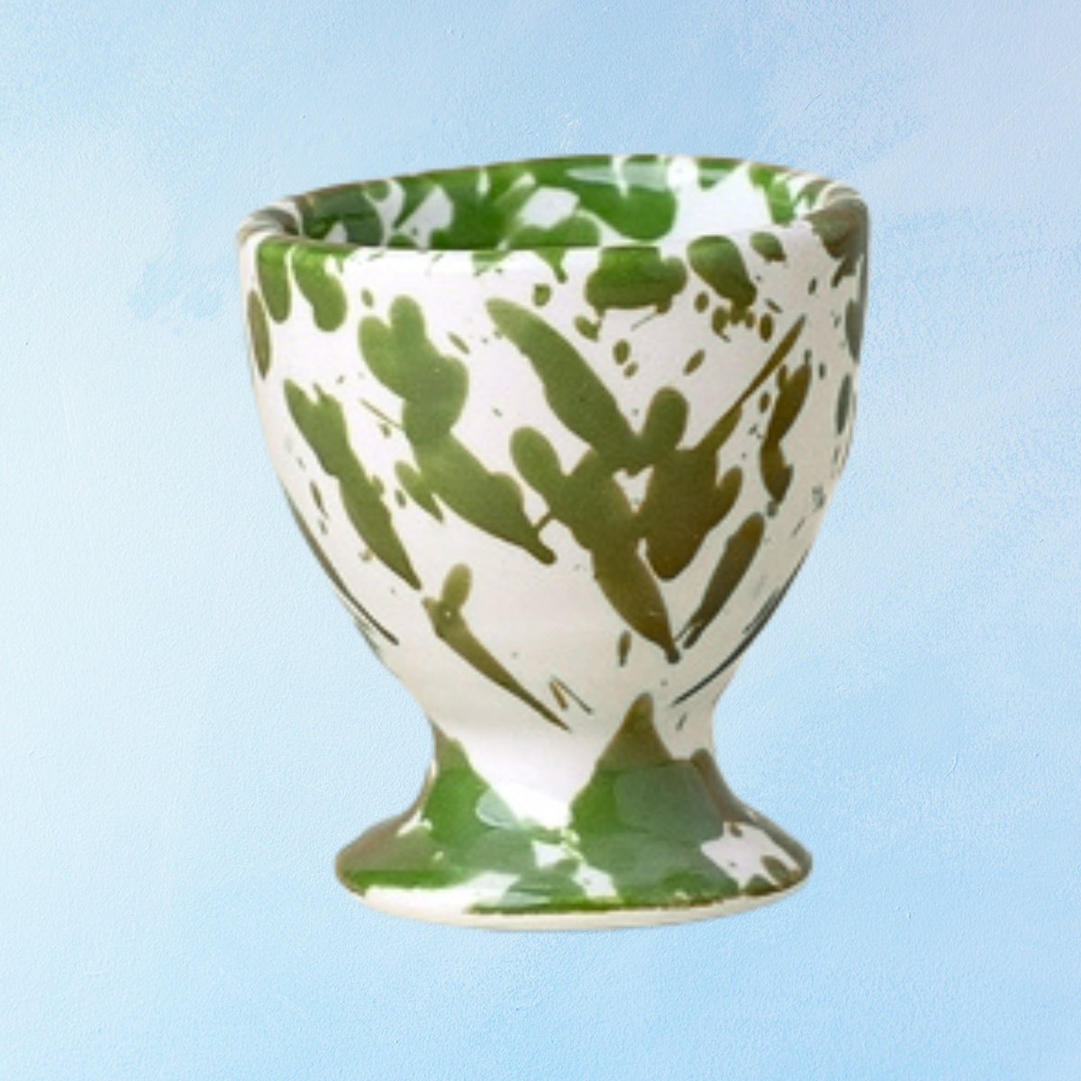 ceramic egg cup with white base and moss toned green splatter design