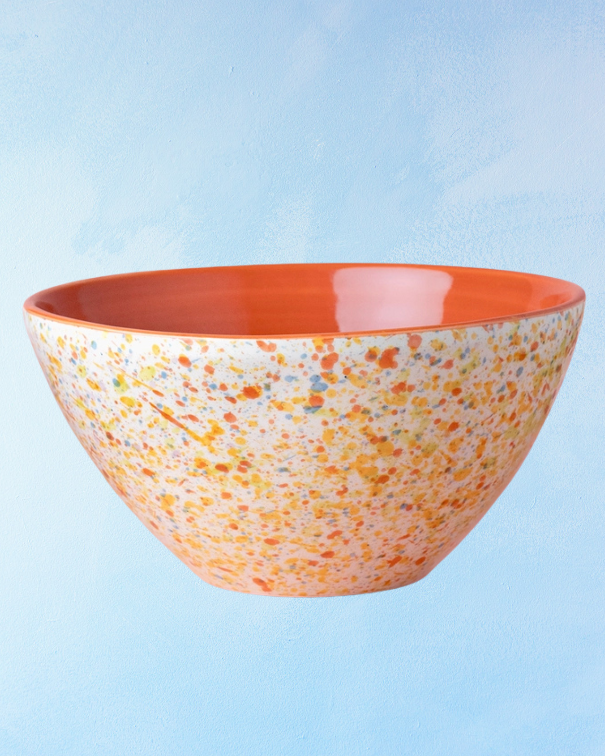 ceramic salad bowl with a white base, orange interior, and rainbow speckle design