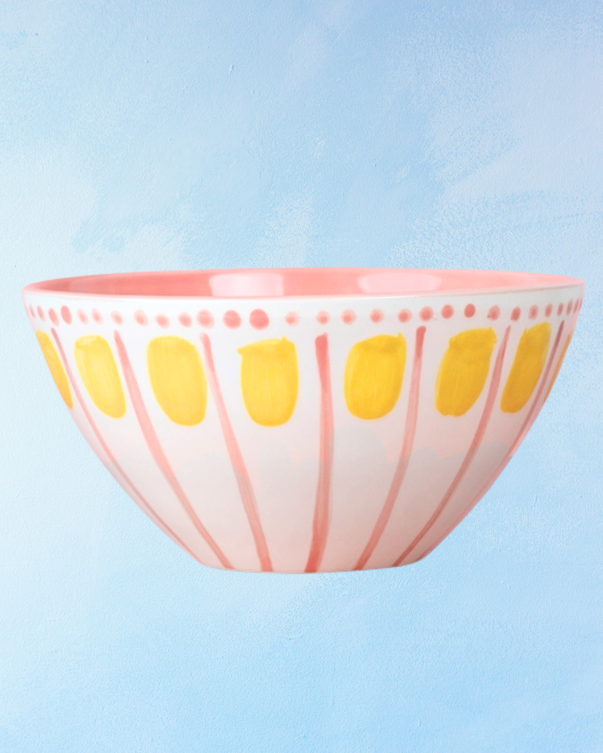 ceramic salad bowl with a white base, pink interior, pink stripes, pink dotted trim, and alternating yellow dot accents