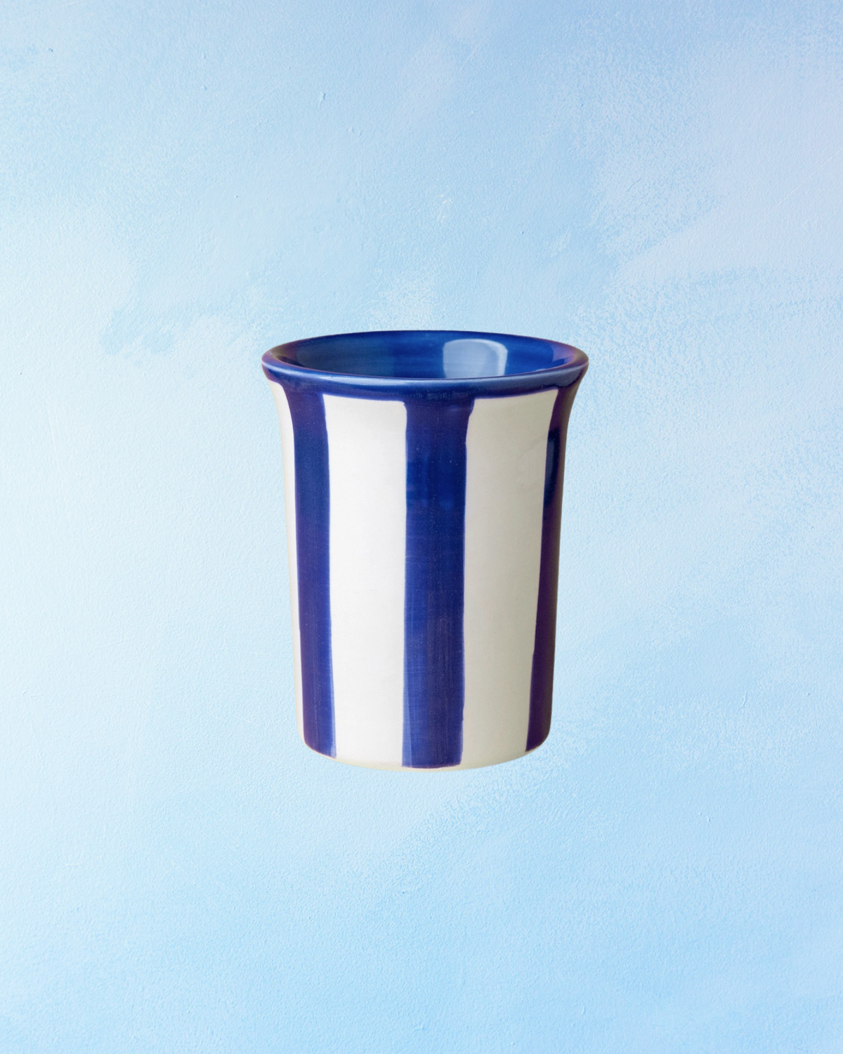 ceramic tumbler cup with dark blue and white stripes and a blue interior