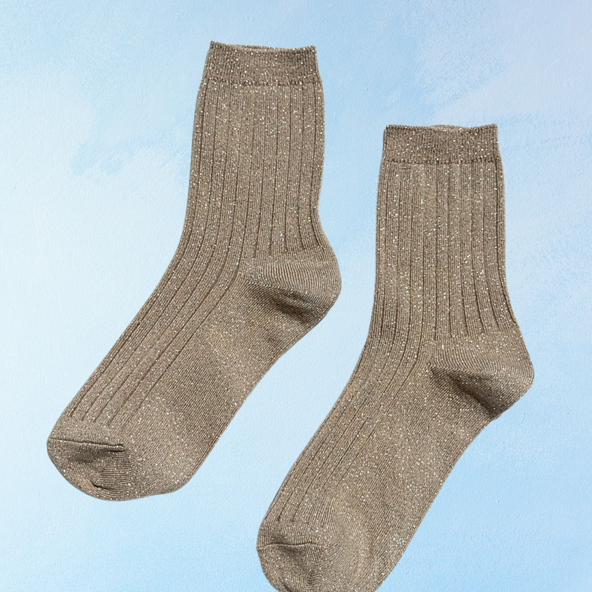 Sparkly beige ribbed socks on a blue background