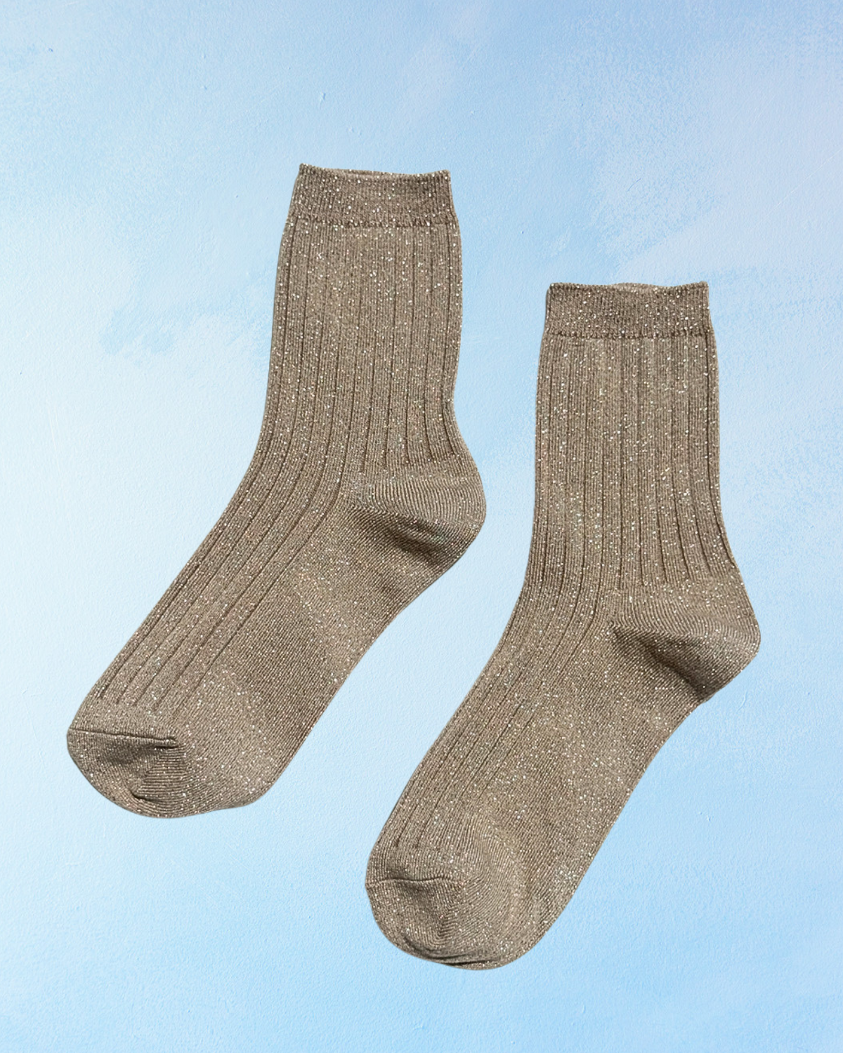 Sparkly beige ribbed socks on a blue background