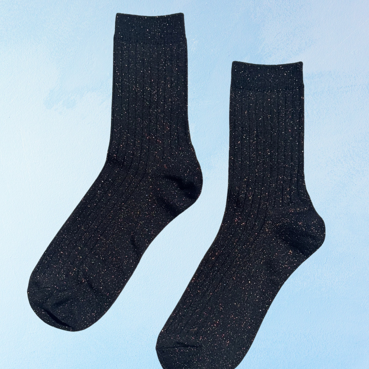 Sparkly black ribbed socks on a bluebackground
