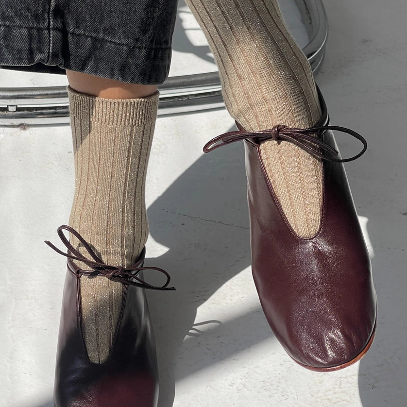 Person wearing beige ribbed socks with brown closed toe shoes