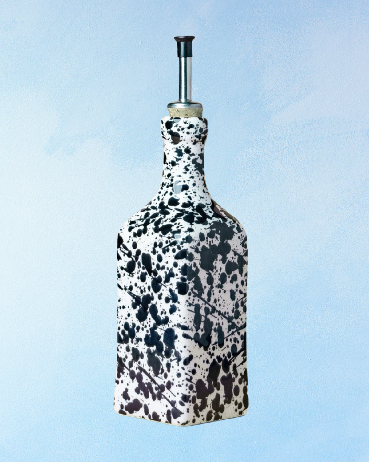 ceramic oil dispenser with square shape, black and white splatter effect, and spout made of cork with a stainless steel tip