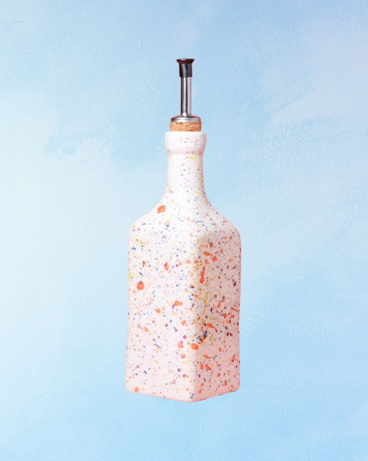 ceramic oil dispenser with square shape, white base and rainbow speckle effect. There is a cork stopper with stainless steel spout inside.