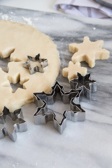 Stainless steel snowflake cookie cutters and cookie dough