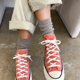 Person wearing coral high-top sneakers and Le Bon Shoppe Winter Glitter socks in Ash