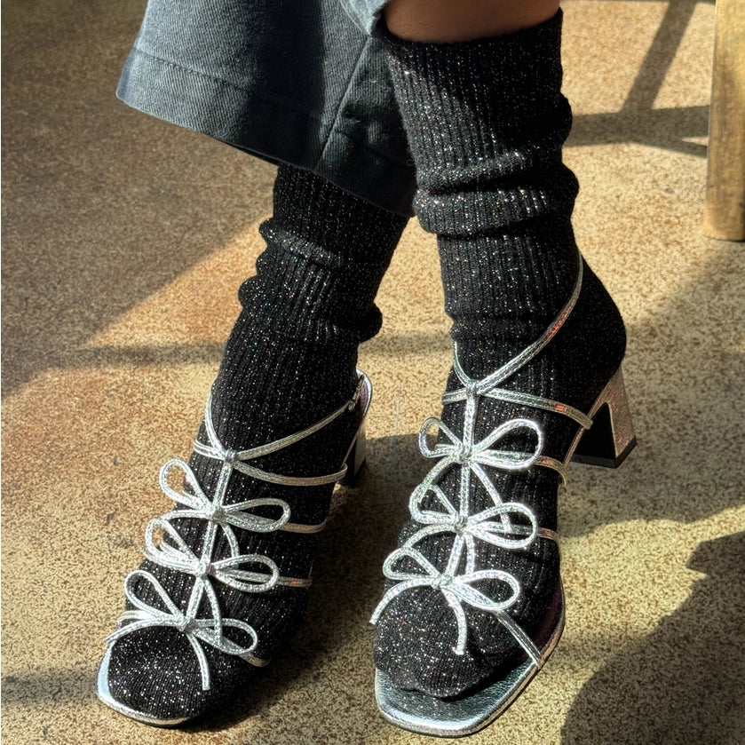 Person wearing Le Bon Shoppe Winter Sparkle socks in Starry Night and silver open toed heels.