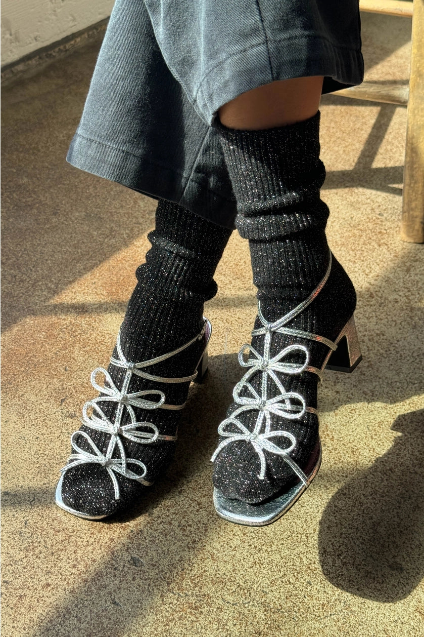 Person wearing Le Bon Shoppe Winter Sparkle socks in Starry Night and silver open toed heels.