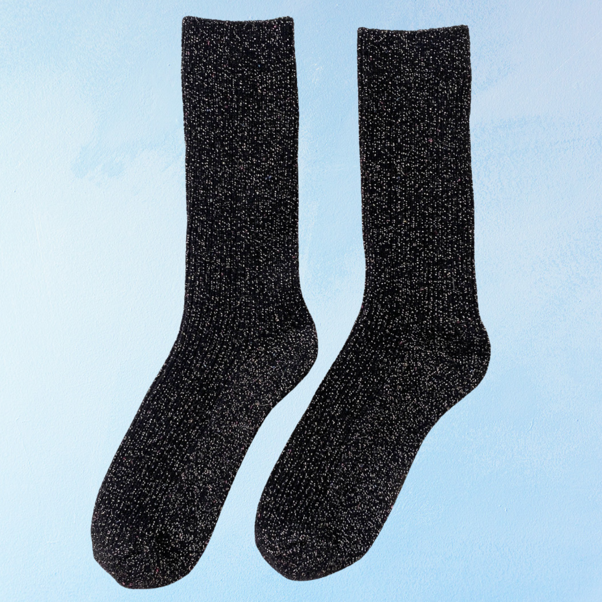 Pair of glittery black socks on a light blue background. Le Bon Shoppe Winter Sparkle in Starry Night.