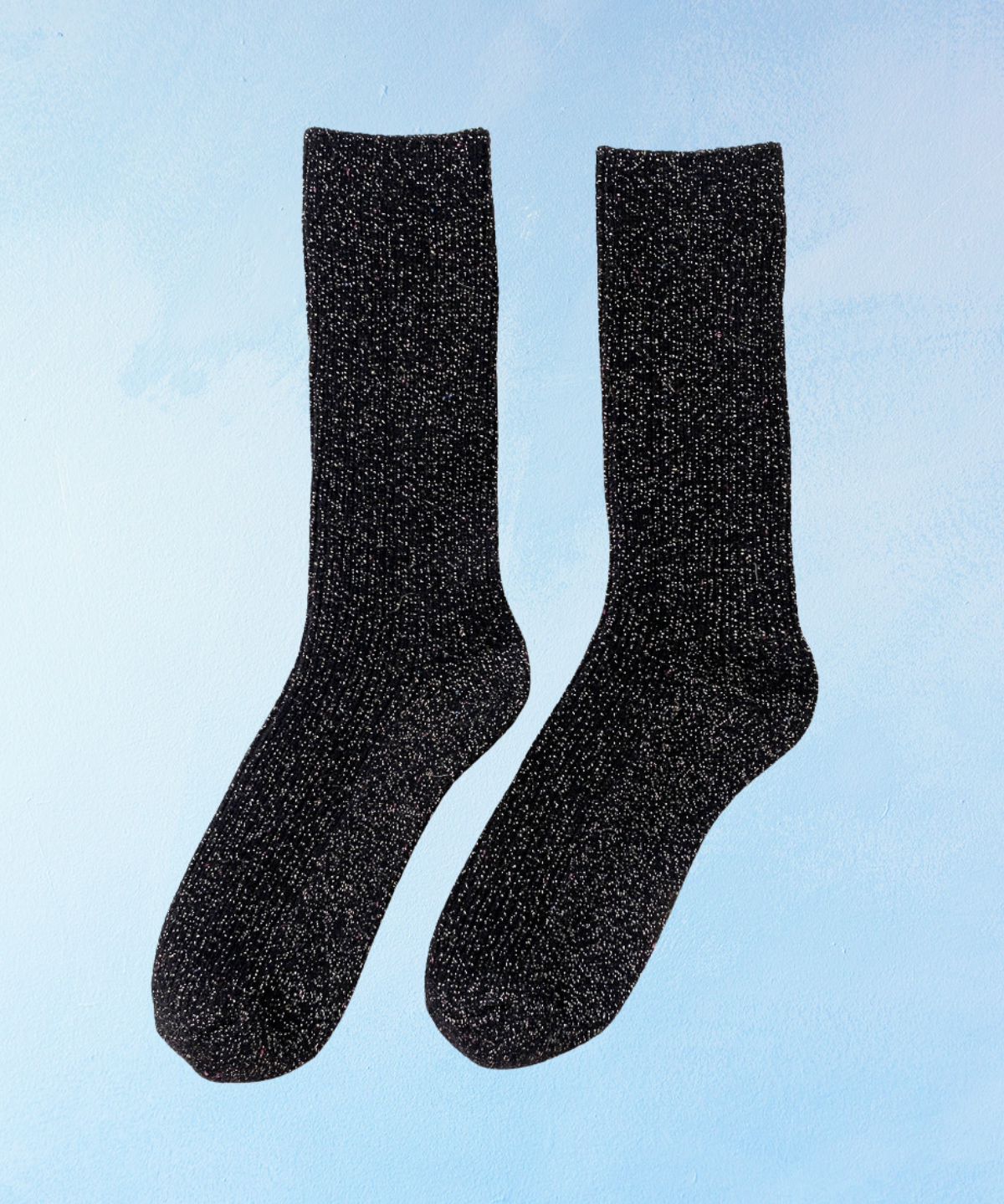 Pair of glittery black socks on a light blue background. Le Bon Shoppe Winter Sparkle in Starry Night.