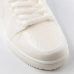 Close up on the toe of a candle shaped like a full-sized nike sneaker