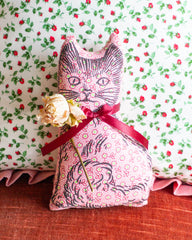 Calico cat balsam pillow in pink with a red ribbon