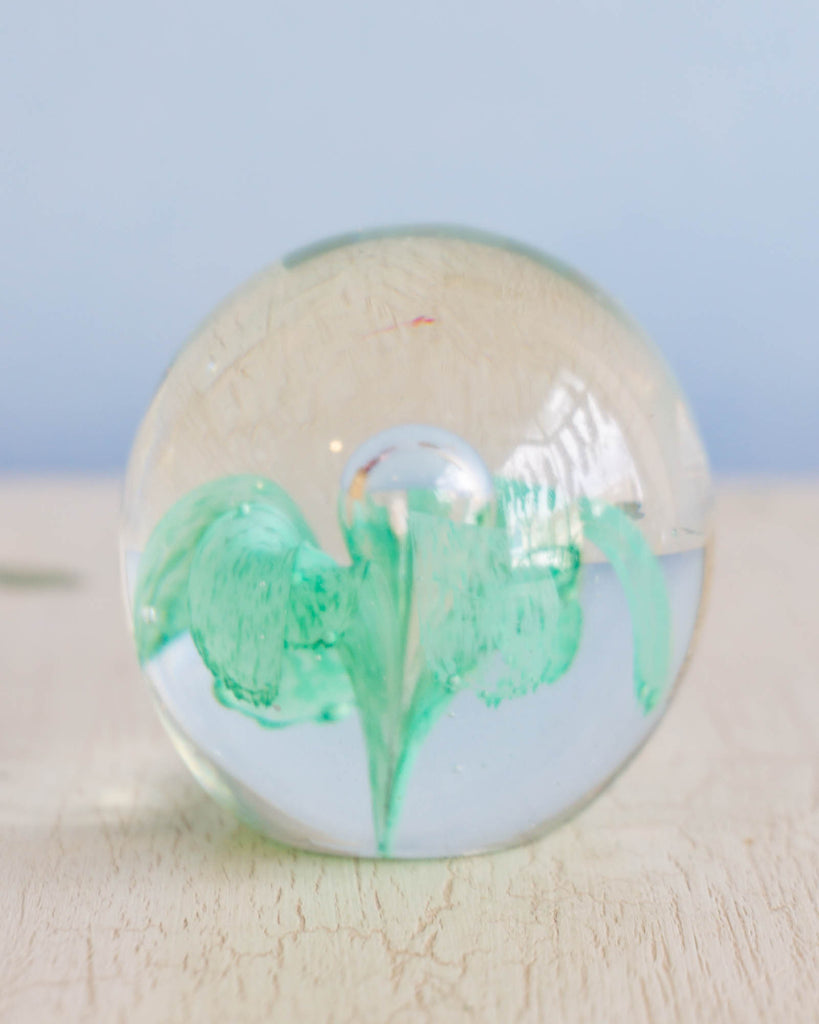 Vintage glass paper weight with an abstract green shape 