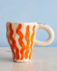 Ceramic hand made mug with wavy orange stripes