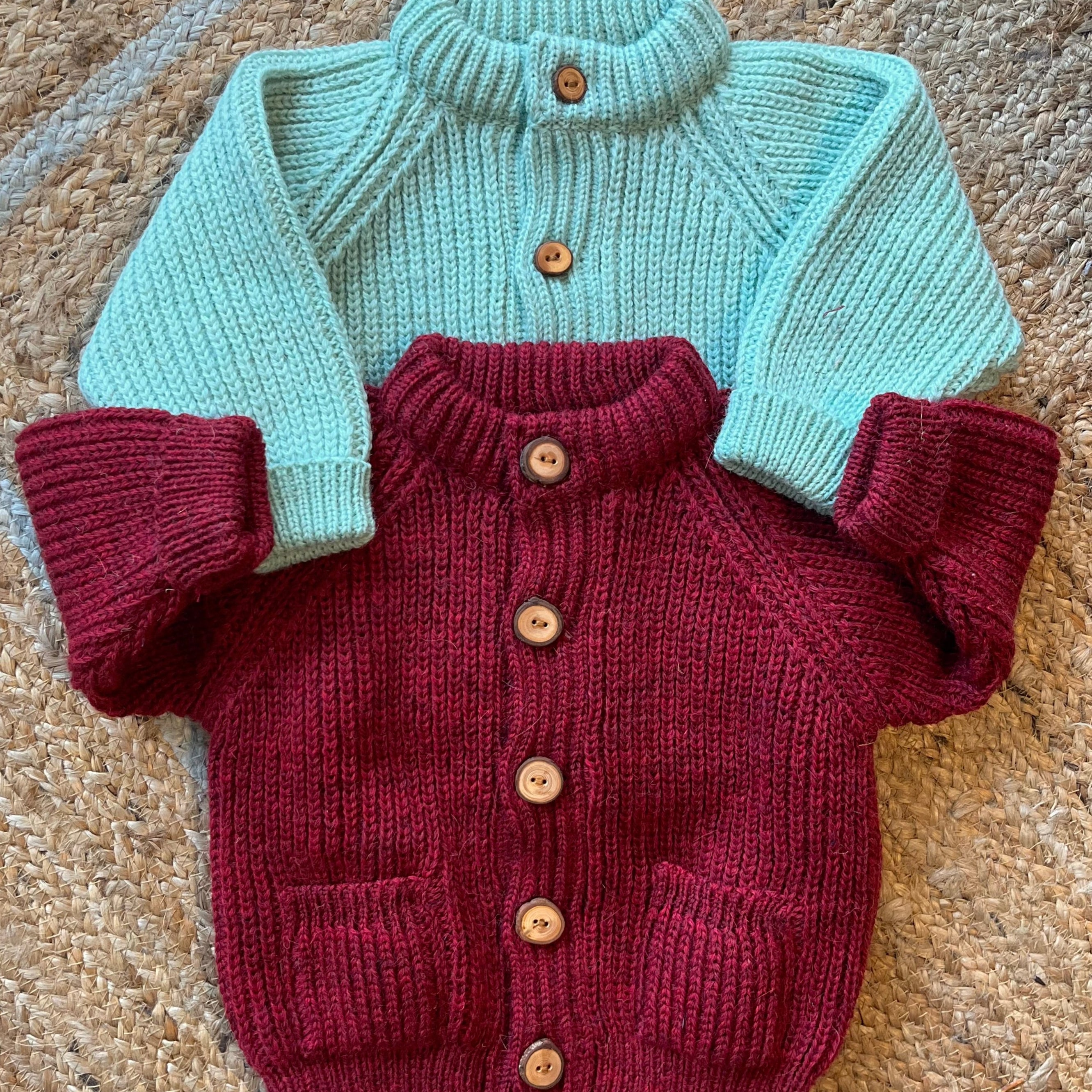 Children's wool cardigans with a crew neck collars, patch pockets, english rib knit stitch body, and a finely detailed raglan sleeve