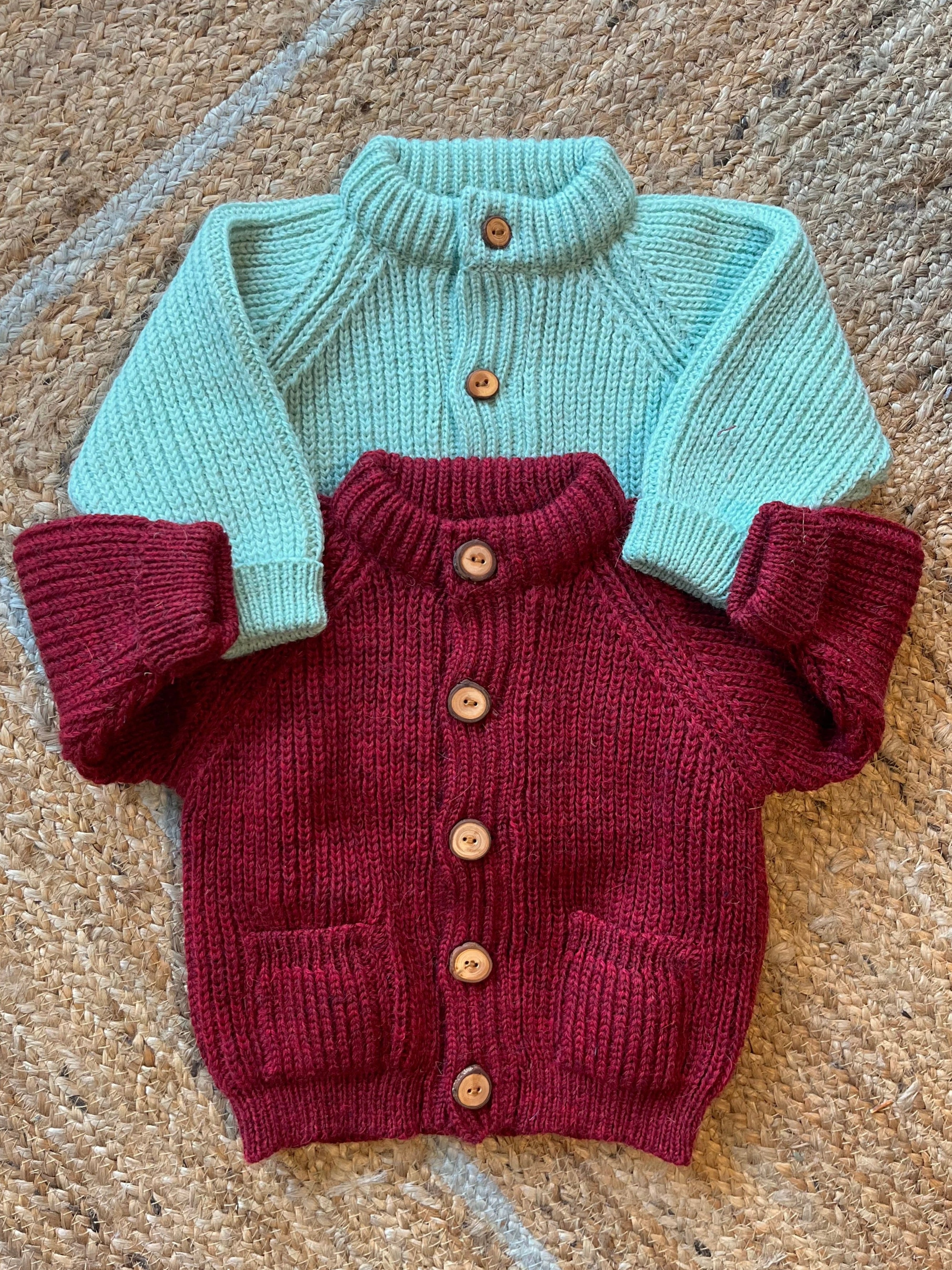 Children's wool cardigans with a crew neck collars, patch pockets, english rib knit stitch body, and a finely detailed raglan sleeve