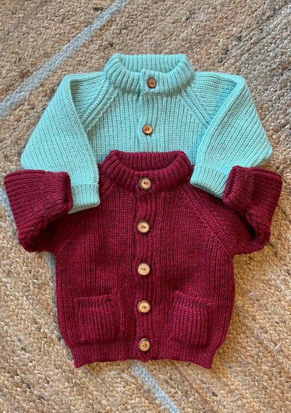Children's wool cardigans with a crew neck collars, patch pockets, english rib knit stitch body, and a finely detailed raglan sleeve