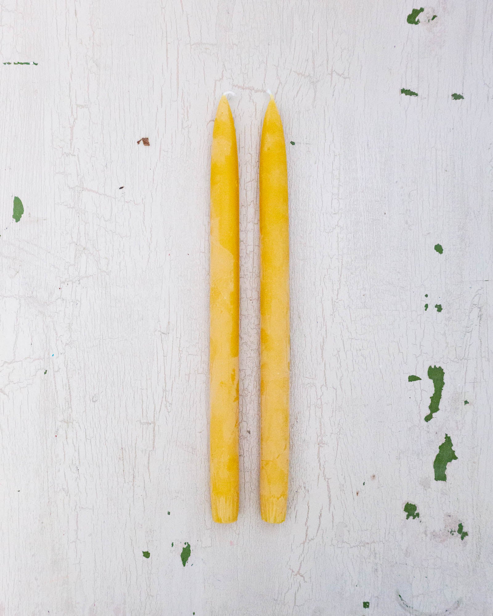 two bright yellow beeswax taper candles by Huckleberry Hives.