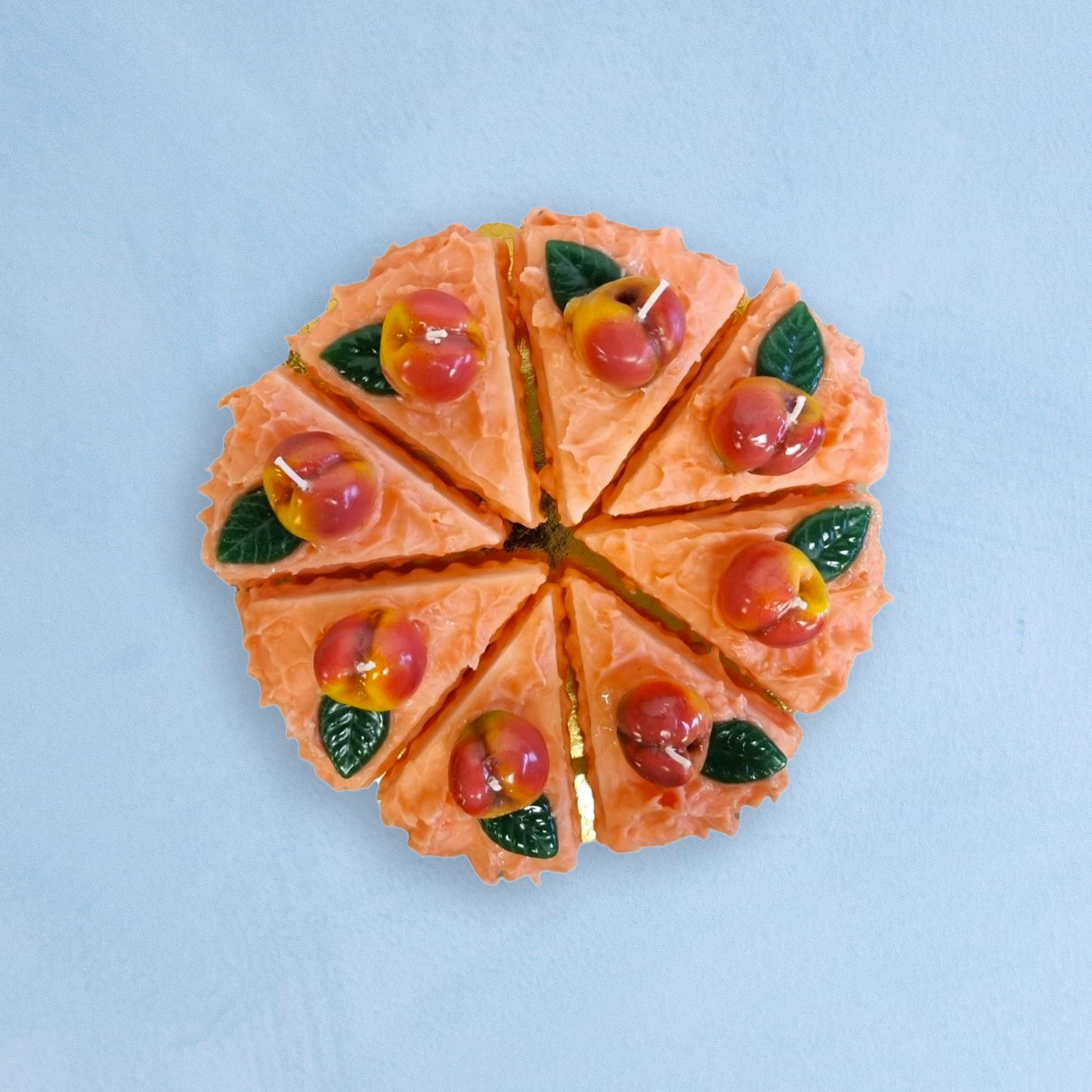 candles that are slices of peach cake arranged into a full cake