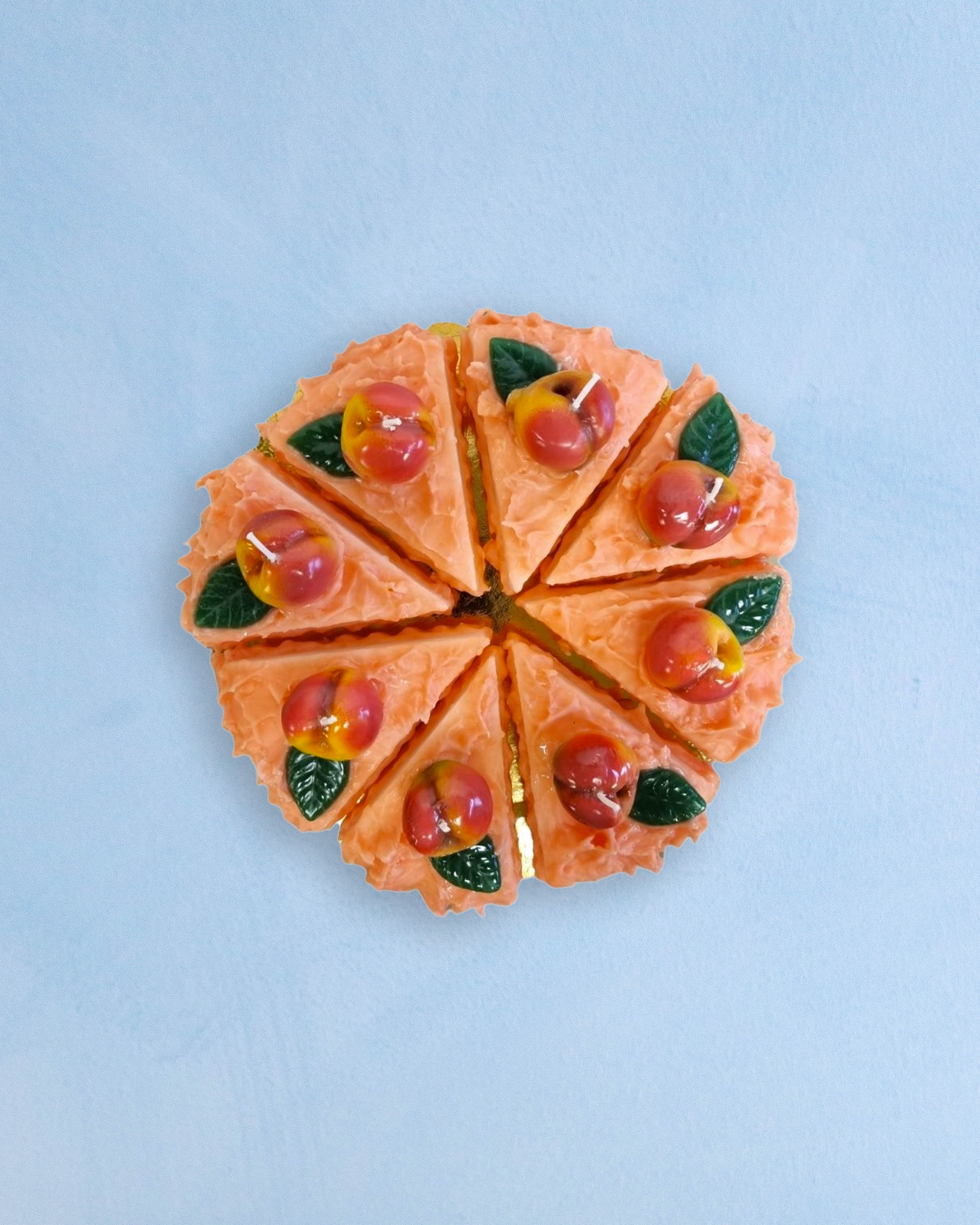 candles that are slices of peach cake arranged into a full cake