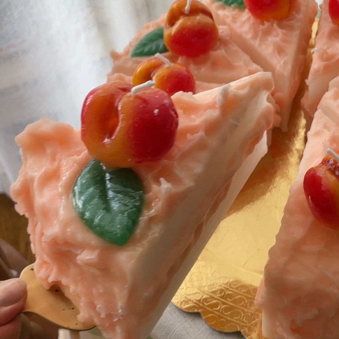 close up on a candle shaped like a slice of peach cake