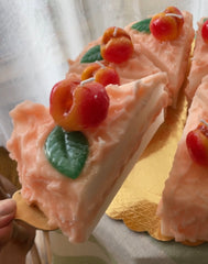 close up on a candle shaped like a slice of peach cake