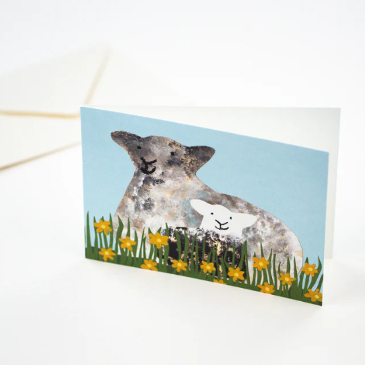 A happy sheep with her lamb having a sit down in some flowers. The perfect new baby, spring or Easter card.