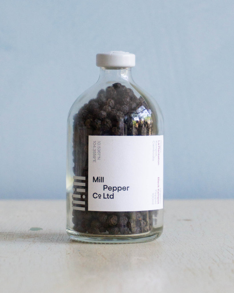 Glass bottle, with white label,  filled with kampot peppercorns by Mill Pepper Co. Ltd.