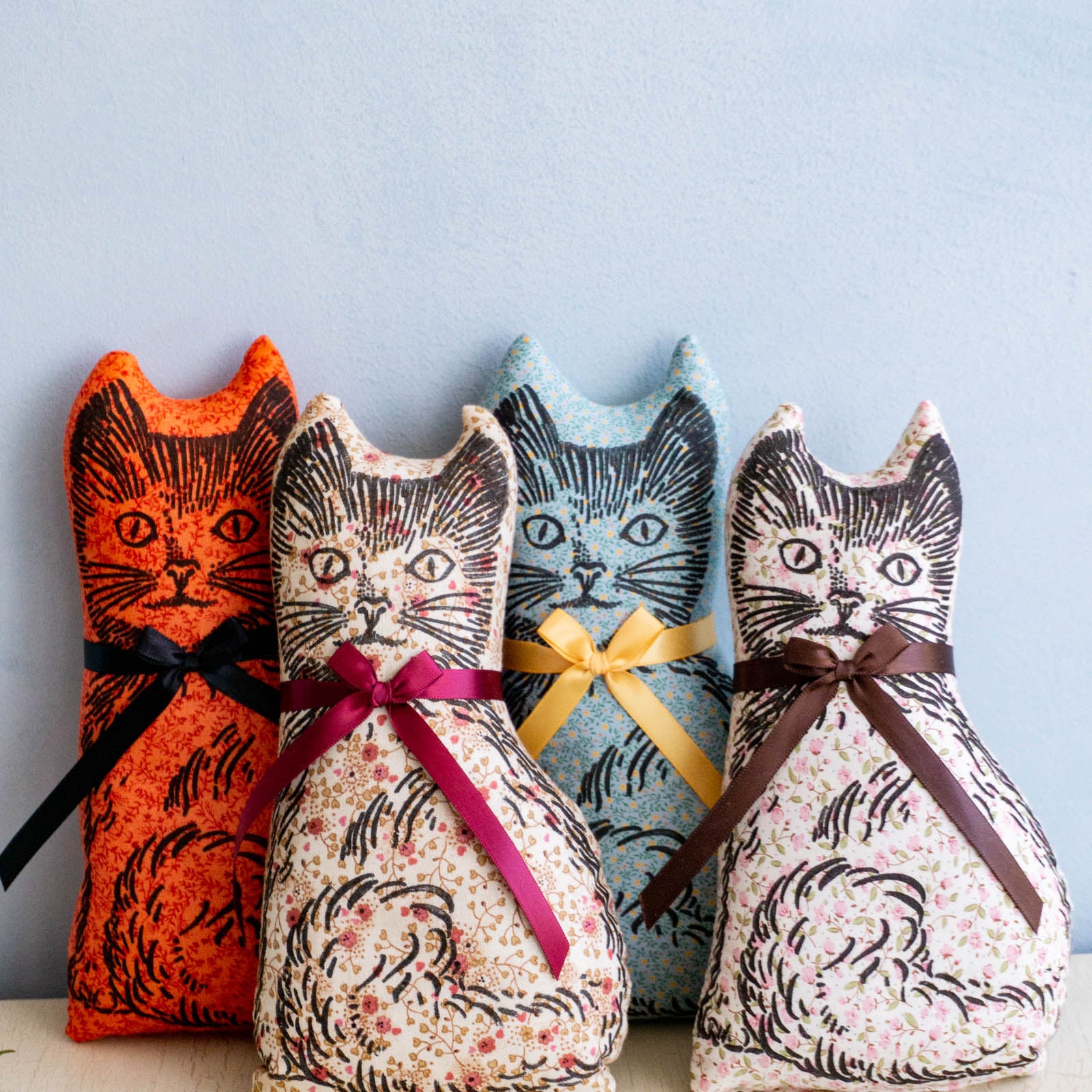 Four calico cat balsam pillows in assorted colours