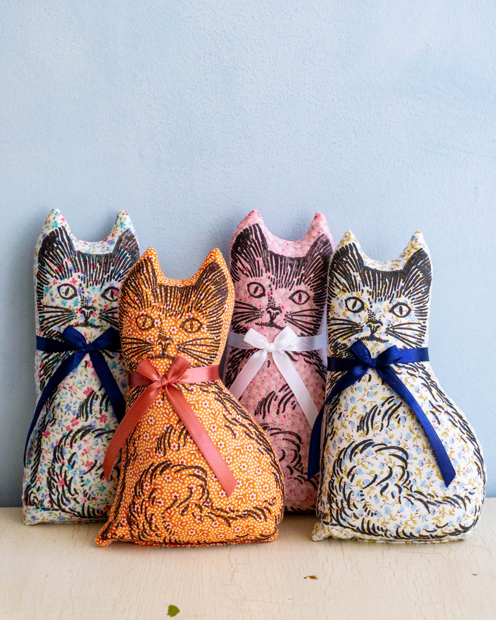 Four calico cat balsam pillows in assorted colours