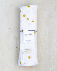 White organic cotton baby blanket featuring a design with yellow and black honeybees.